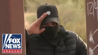 Human smuggler salutes camera at southern border [upl. by Eirod]