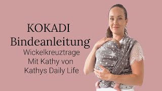 Babytrage Anleitung KOKADI Wickelkreuztrage vorne auf dem Bauch getragen Tragetuch Binden [upl. by Ardin]